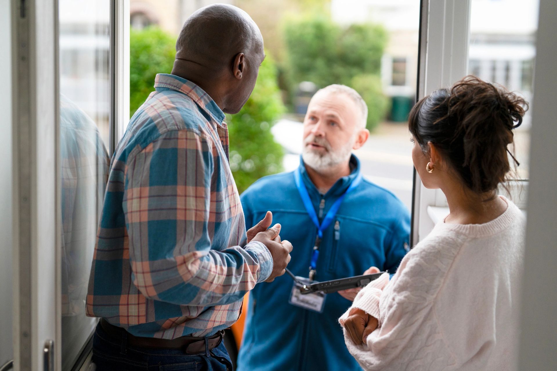 Engineer discussing a quote with customers at their front door